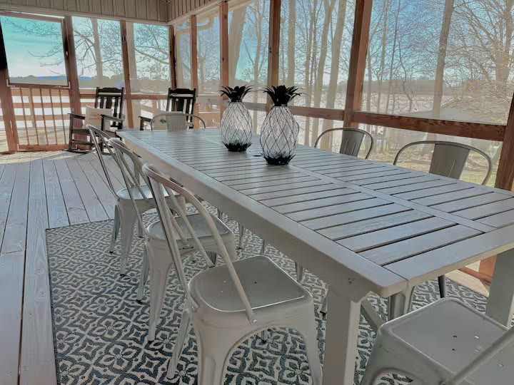 The Angler's Canoe Lake House screened porch dining at a direct-booking vacation rental in Cedar Bluff, Alabama